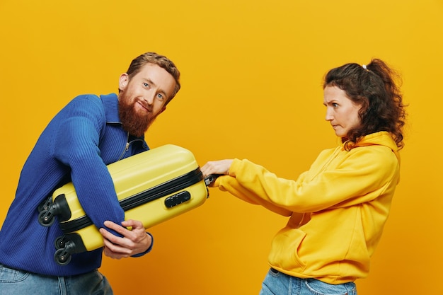 Kobieta i mężczyzna uśmiechają się walizki w dłoni z żółtą i czerwoną walizką uśmiechając się wesoło i krzywym żółtym tłem jadąc na wycieczkę rodzinna wycieczka nowożeńcy
