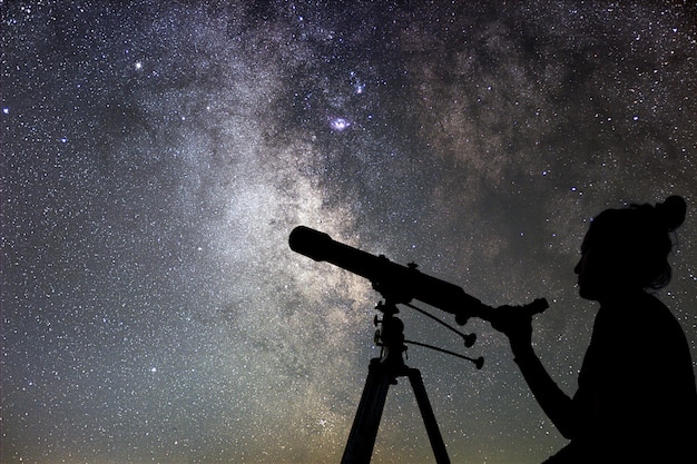 Zdjęcie kobieta i nocne niebo oglądanie gwiazd kobieta z teleskopem