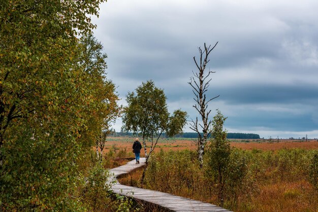 Zdjęcie kobieta idąca po promenadzie na tle nieba