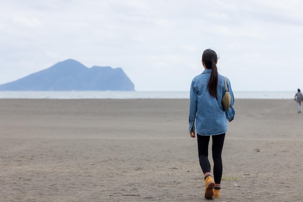 Kobieta idąca wzdłuż piaszczystej plaży w Yilan na Tajwanie