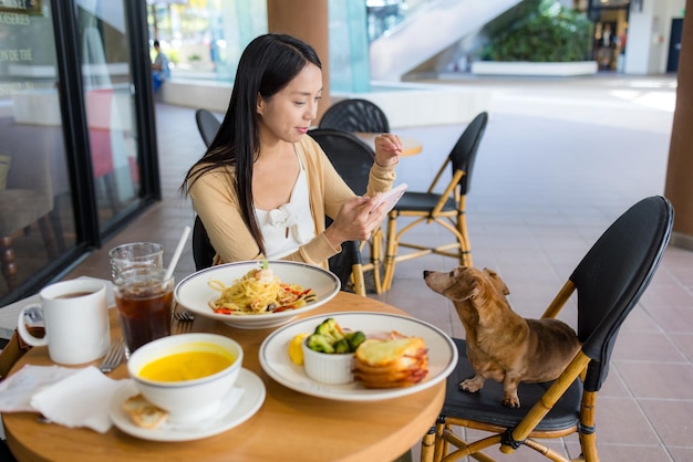 Kobieta idzie do restauracji z psem w centrum handlowym.