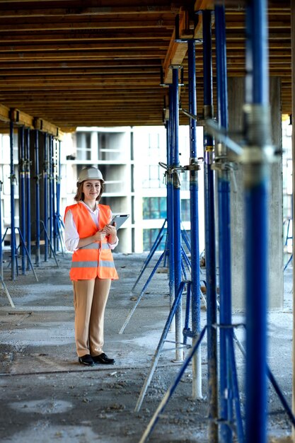 Kobieta inżynier budowlany Architekt z tabletem na budowie Młoda kobieta patrząca na plac budowy na tle Koncepcja budowy