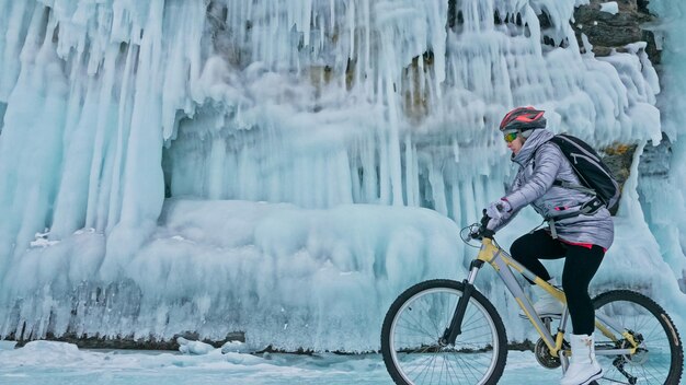 Kobieta jedzie na rowerze w pobliżu lodowej groty Skała z lodem c