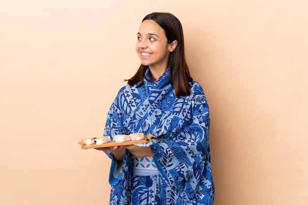 Kobieta jest ubranym kimono i trzyma suszi