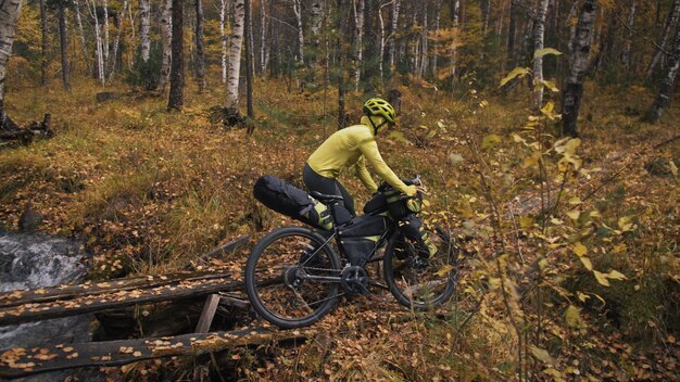 Kobieta jeździ na rowerze terenowym mieszanym z bikepackingiem. Podróż podróżnika z torbami rowerowymi. Bikepacking turystyki sportowej.