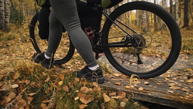 Zdjęcie kobieta jeździ na rowerze terenowym mieszanym z bikepackingiem. podróż podróżnika z torbami rowerowymi. bikepacking turystyki sportowej.