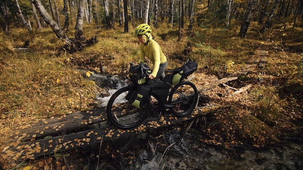 Kobieta jeździ na rowerze terenowym mieszanym z bikepackingiem. Podróż podróżnika z torbami rowerowymi. Bikepacking turystyki sportowej.