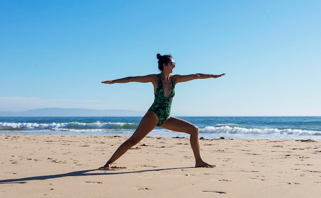Kobieta jogi robi jogi na plaży dla dobrego samopoczucia zdrowego stylu życia.