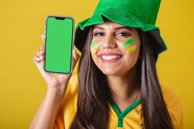 Kobieta kibicująca brazylijskiej mundialu 2022 trzymająca telefon komórkowy i pokazująca ekran aplikacji