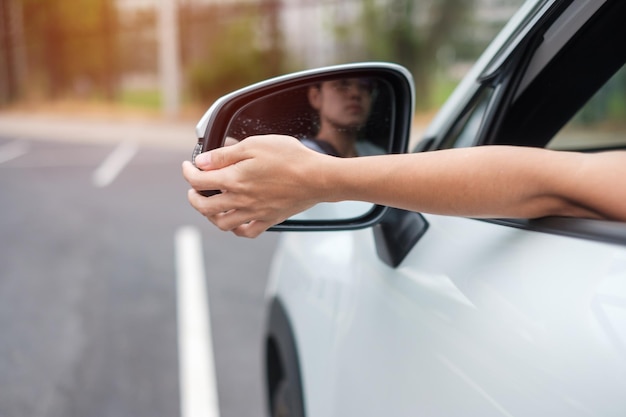 Kobieta kierowca dostosowujący lusterko boczne samochodu Podróż w podróży i bezpieczeństwo Koncepcje transportu