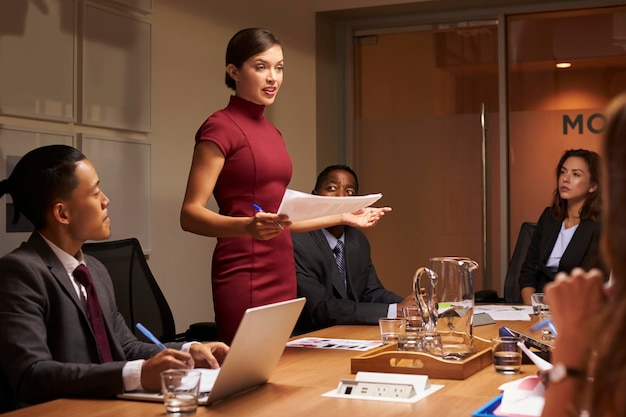 Kobieta kierownik stojący z dokumentami na spotkaniu biznesowym