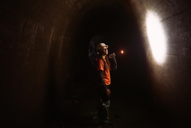 Kobieta kopaczka z latarką bada tunel