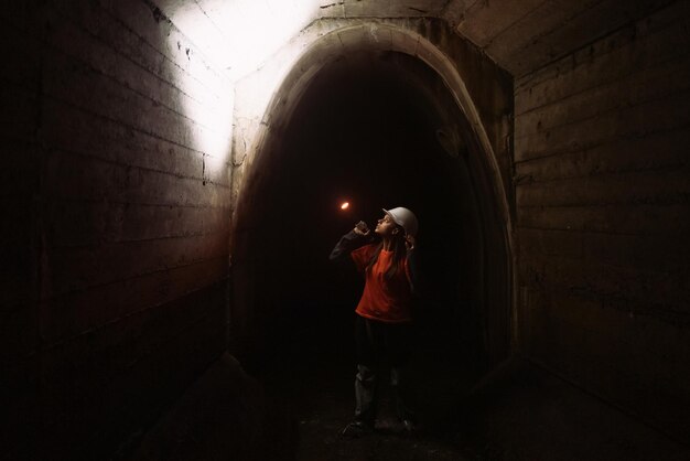 Kobieta kopaczka z latarką bada tunel