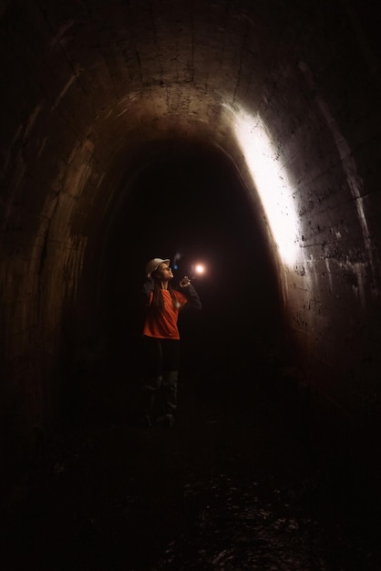 Kobieta kopaczka z latarką bada tunel