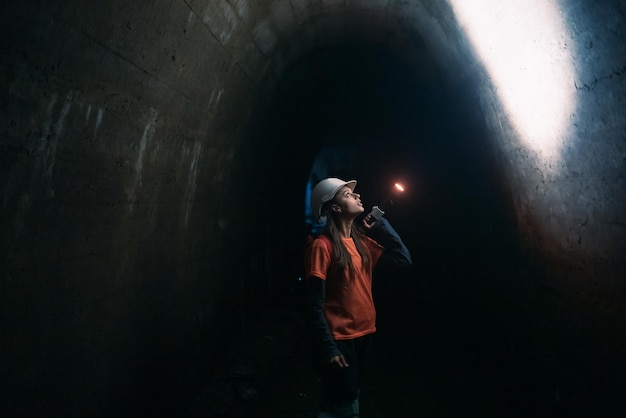 Kobieta kopaczka z latarką bada tunel