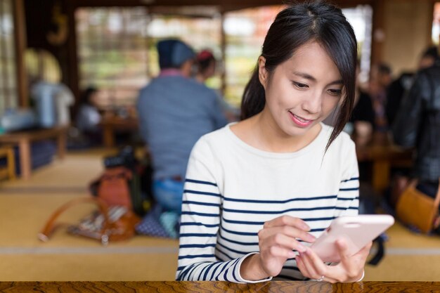 Kobieta korzysta z telefonu komórkowego w japońskiej restauracji