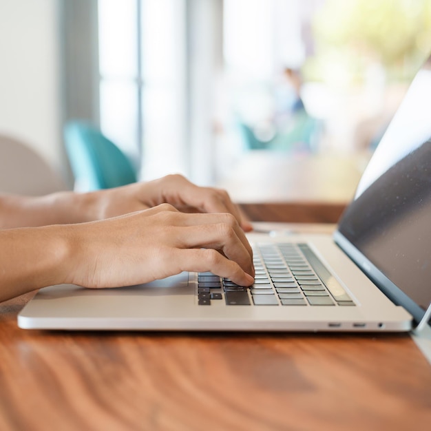 Kobieta korzystająca z laptopa niezależna kobieta pisania na klawiaturze komputer notebook w kawiarni lub nowoczesnej technologii biurowej cyfrowej koncepcji online i sieci