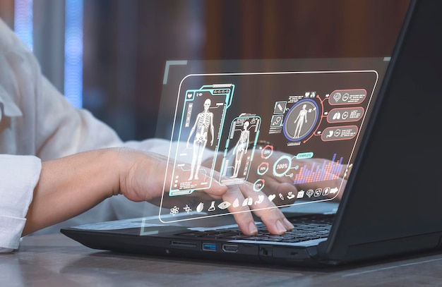 Zdjęcie kobieta korzystająca z laptopa z cyfrową anatomią medyczną i ludzką na hologramowym interfejsie wirtualnego ekranu