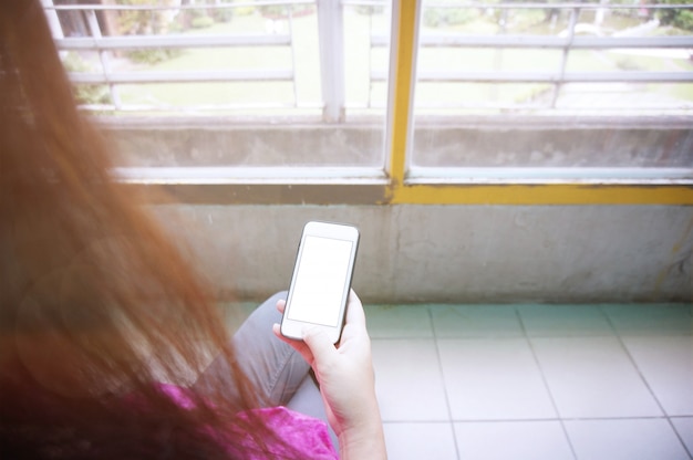Kobieta korzystająca z telefonu komórkowego inteligentnego, wysyłanie masaży Telefon z białymi ekranami wideo, praca świąteczna przy użyciu koncepcji internetTravel przygotowania.