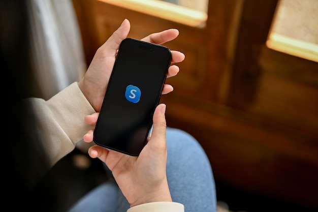 Kobieta Korzystająca Ze Skype'a Na Swoim Smartfonie W Kontakcie Z Kimś Z Iphone'a Z Logo Skype'a