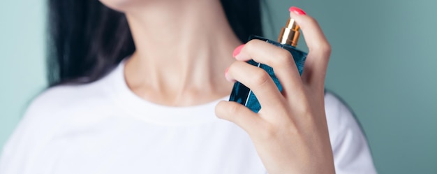 Kobieta kropi perfumy na szyję