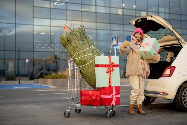 Zdjęcie kobieta kupuje choinkę i prezenty w centrum handlowym