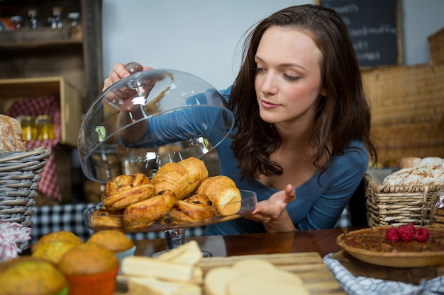 Zdjęcie kobieta kupuje rogalika w kasie piekarni