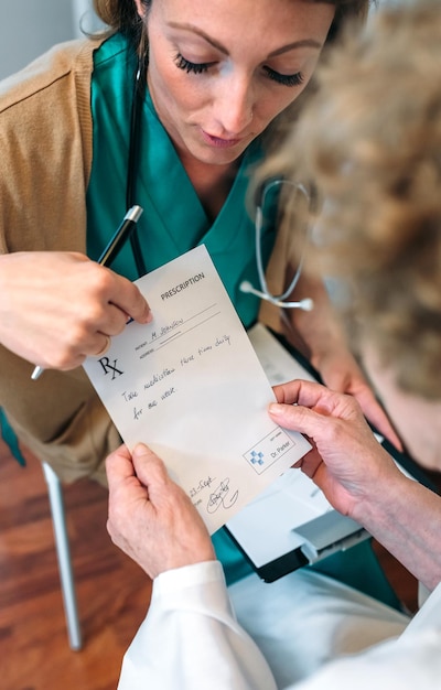 Kobieta lekarz daje receptę starszej pacjentce