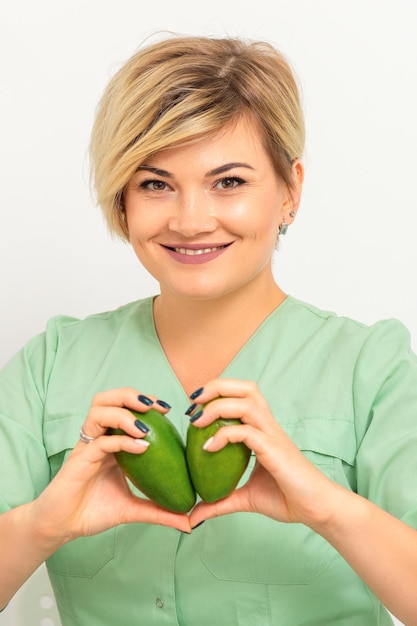 Zdjęcie kobieta lekarz dietetyk noszący zieloną odzież roboczą z zielonymi organicznymi owocami awokado koncepcja zdrowego stylu życia