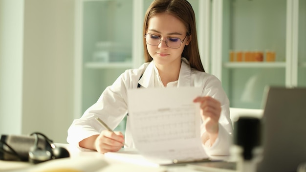 Kobieta lekarz dokonuje wpisów w dzienniku, a lekarz wypełnia dokumentację medyczną