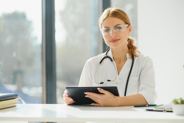 Kobieta lekarz przy użyciu komputera typu tablet w szpitalu