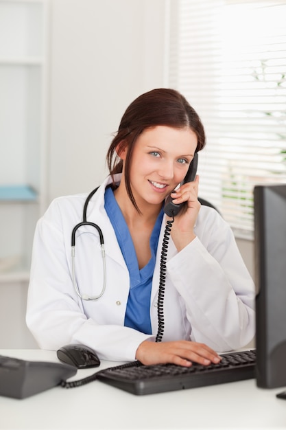 Zdjęcie kobieta lekarz telefonicznie i patrząc