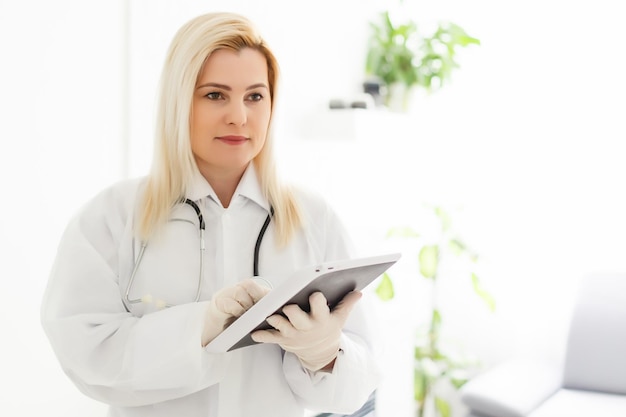 Zdjęcie kobieta lekarz trzymając tablet pc. zbliżenie dłoni lekarza. pojęcie usług medycznych i opieki zdrowotnej.