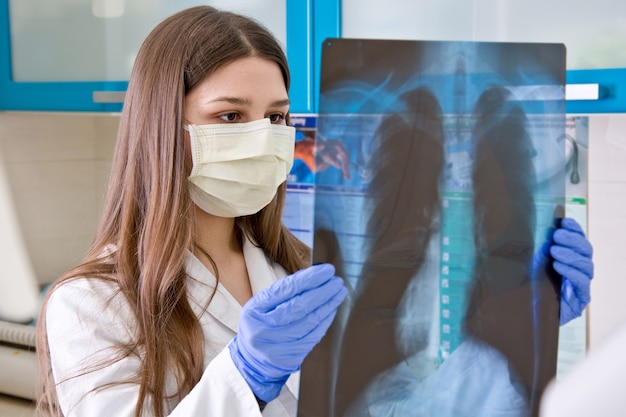 Kobieta lekarz w szpitalu patrzy na prześwietlenie płuc.