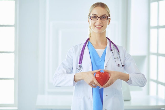 Kobieta lekarz ze stetoskopem trzyma serce.
