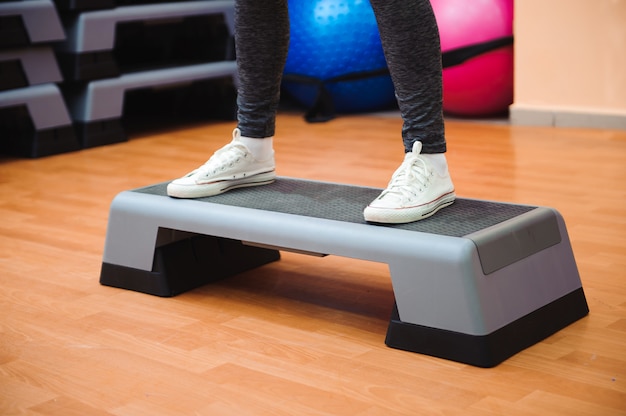 Kobieta lekkoatletycznego trener robi aerobik klasy z steppers. Sport