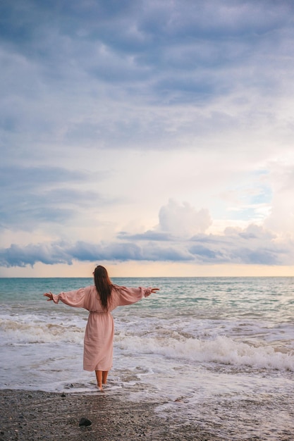 Kobieta leżąc na plaży, ciesząc się letnimi wakacjami, patrząc na morze