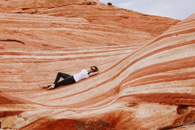 Zdjęcie kobieta leżąca na skałach w valley of fire state park