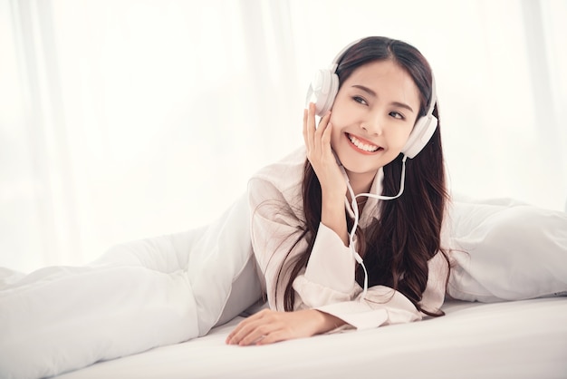 kobieta lubi słuchać muzyki przez słuchawki w sypialni
