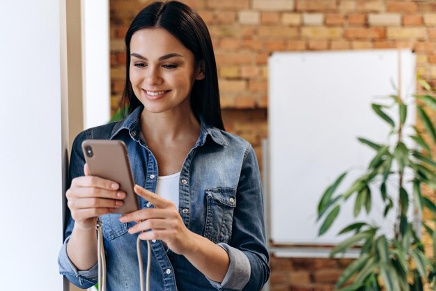 Kobieta menedżer szuka informacji na telefon komórkowy w pomieszczeniu