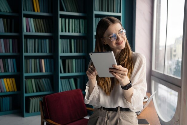 Kobieta menedżer w przestrzeni biurowej coworkingowej w miejscu pracy używa tabletu