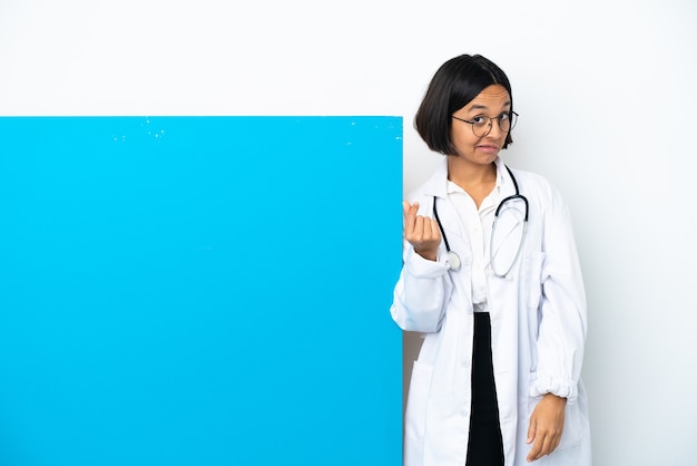Kobieta młody lekarz rasy mieszanej z dużym plakietką na białym tle dokonywania gest pieniędzy