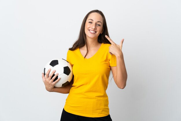 Kobieta młody piłkarz na pojedyncze białe ściany, dając kciuki do góry gestu