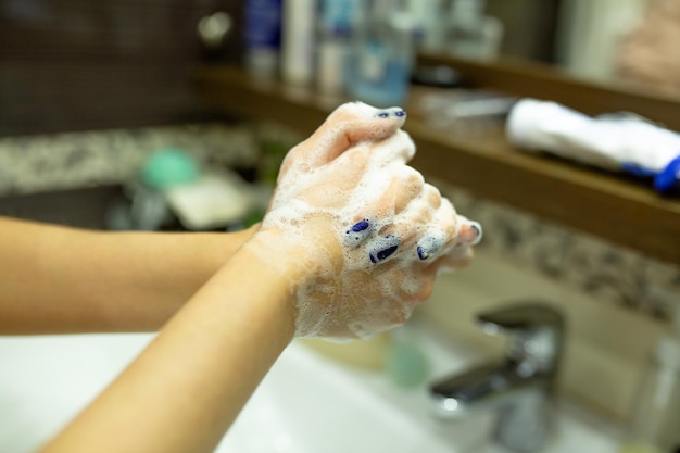 Kobieta myjąca ręce, aby uniknąć pandemii