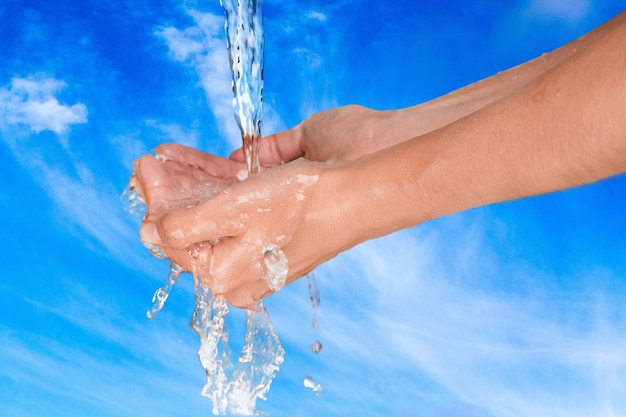 Kobieta myje ręce w czystej wodzie na niebieskim tle