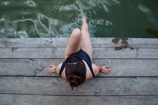 Kobieta na drewnianym molo w kostiumie kąpielowym