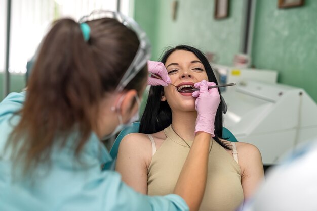 Kobieta na fotelu dentystycznym lecząca ząb bez bólu