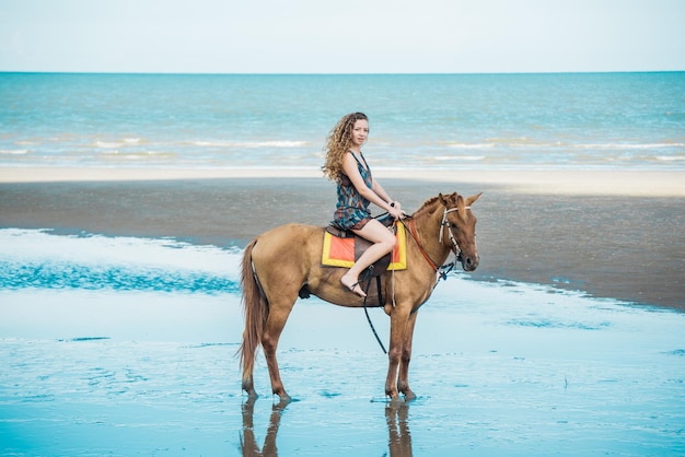 Kobieta na koniu na plaży.