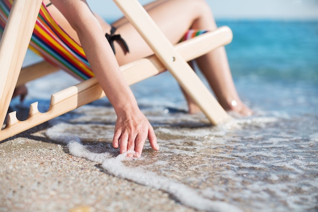 Kobieta na pięknej plaży relaksuje się na krześle
