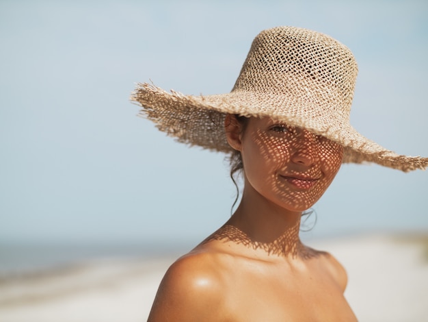 Kobieta na plaży w kapeluszu przeciwsłonecznym na wakacjach